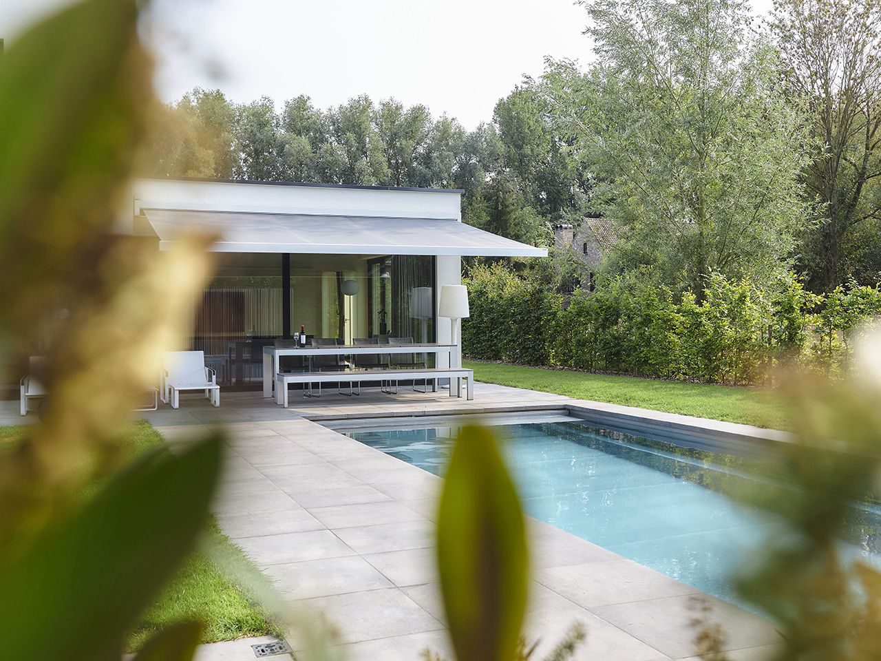 Banne solaire Winsol LINASOL au design linéaire, près d’une piscine
