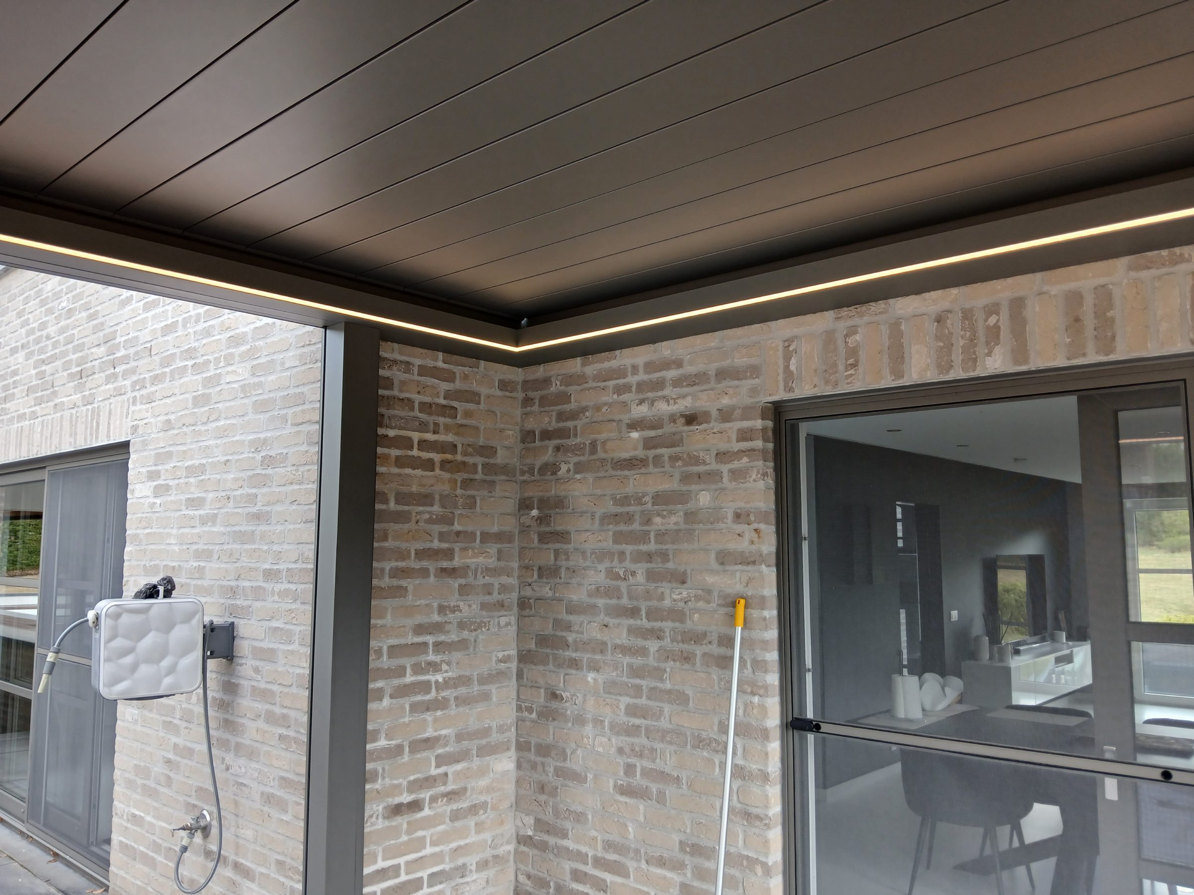 Pergola LED contre une façade en brique